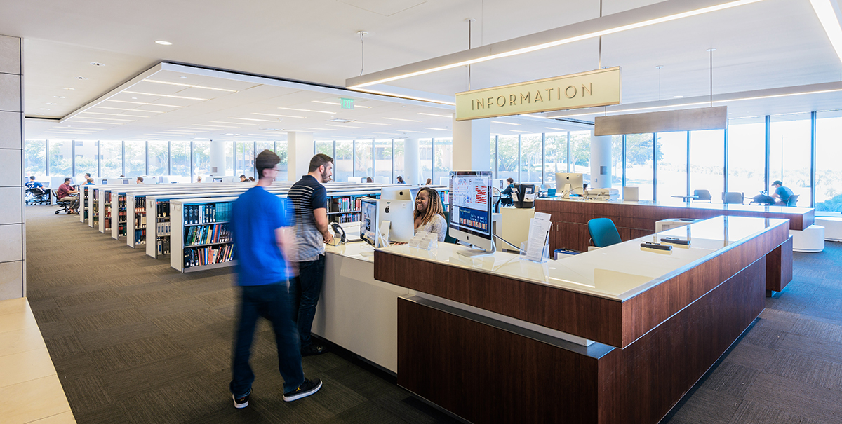 Students asking for help at the Information Desk at the William H. Hannon Library.