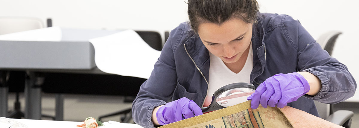 Student examining historical book. 