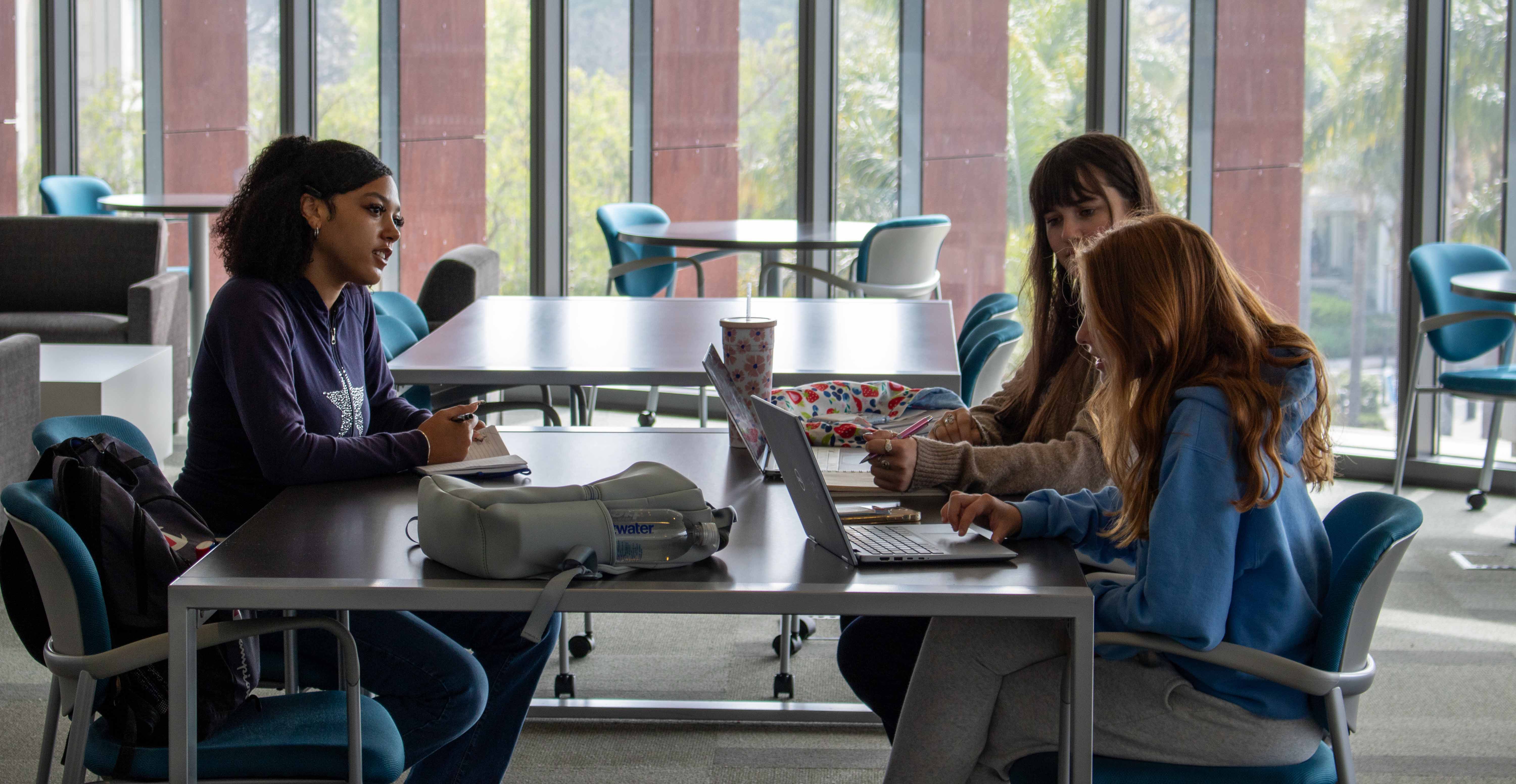 Students with computers in a study table at the library